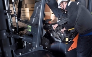 Time to get your forklift checked - person checking the engine of a forklift truck