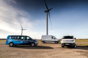 Dawsongroup's Environmental Commitment - 3 electric vans in front of wind turbines